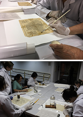 a primeira imagem mostra um papel antigo em cima de uma mesa branca. O tronco de uma pessoa com jaleco aparece ao fundo, ao lado dela está uma mão que está mexendo no papel. Na superfície ainda há outros papéis. A segunda foto mostra um grupo de seis mulheres participando do workshop. Todas estão de jaleco branco, algumas vestem luvas e máscaras cirúrgicas. Elas estão sentadas em uma mesa que contém pincéis, papéis, algodão, régua e outros itens. 