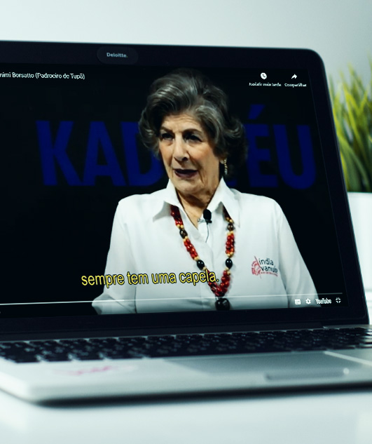 #PraCegoVer - Descrição da imagem para cegos: a imagem mostra um notebook aberto em cima de uma superfície. Na tela aparece uma parte do vídeo com a imagem da gerente.