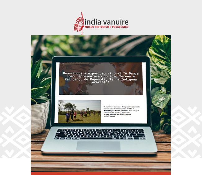  Imagem com fundo claro e detalhes gráficos discretos nas laterais. Na parte superior, centralizado, está o logotipo do Museu Histórico e Pedagógico Índia Vanuíre, em vermelho. Abaixo, uma fotografia mostra um notebook apoiado sobre uma superfície de madeira, cercado por plantas verdes. Na tela do computador, vê-se a página inicial da exposição virtual com o texto Bem-vindos à exposição virtual A Dança como representação do Povo Terena e Kaingang, de Kopenoti, Terra Indígena Araribá. Abaixo do título, aparece uma imagem menor de pessoas dançando em um campo aberto e um trecho explicativo sobre a exposição.