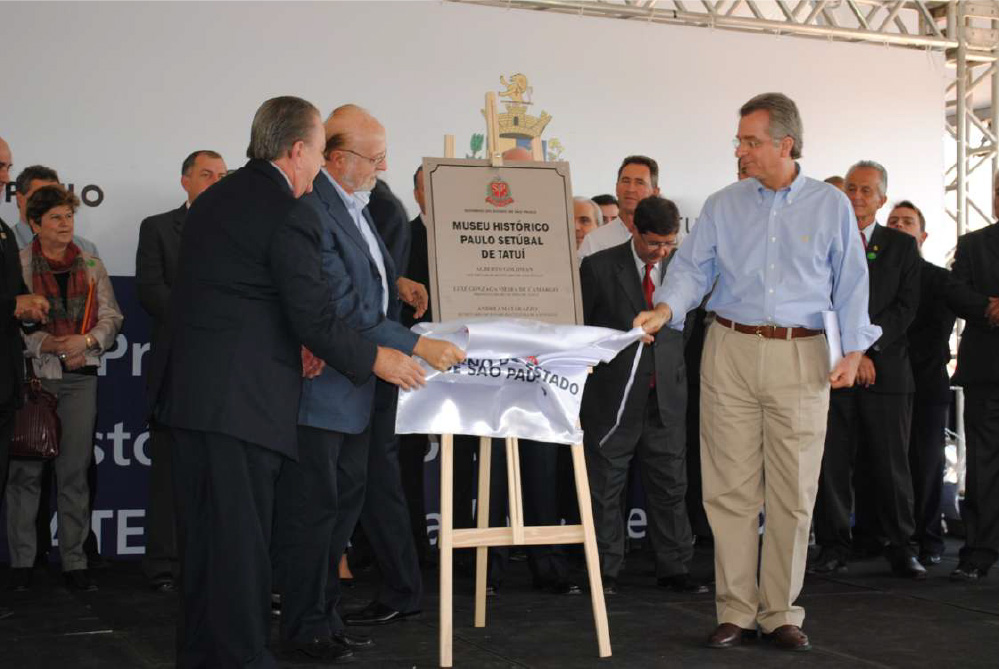 PraTodosVerem – A imagem mostra uma placa de inauguração do Museu Histórico Paulo Setúbal de Tatuí sendo descoberta por políticos em uma ato solene. 
